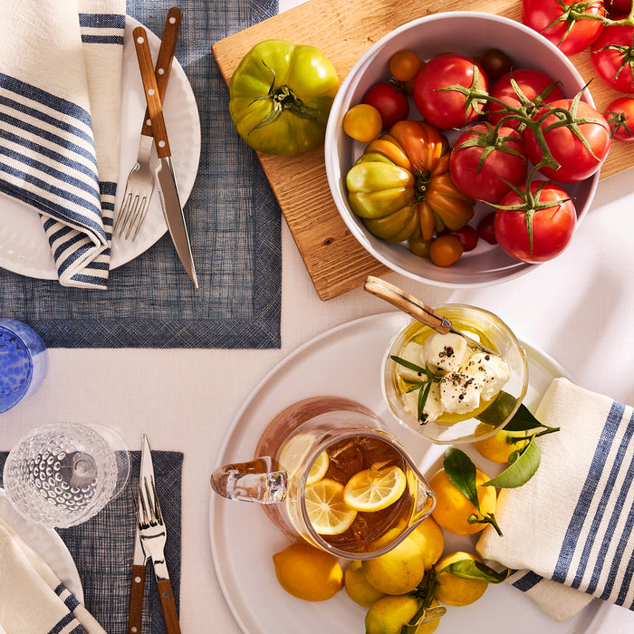 White HG Melamine Serving Platter with lemons, iced tea, and mozzarella, on a table with striped linens.
